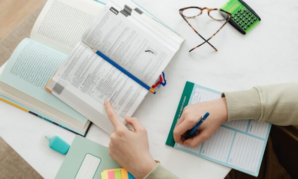 Person Studying And Writing Notes On Paper