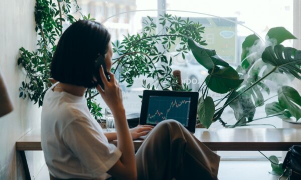 Businesswoman in White Shirt Sitting on Chair while Having Phone Call