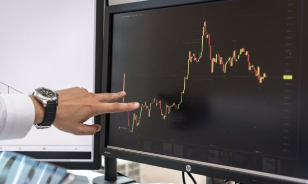 Hand on Screen with Charts of Cryptocurrency